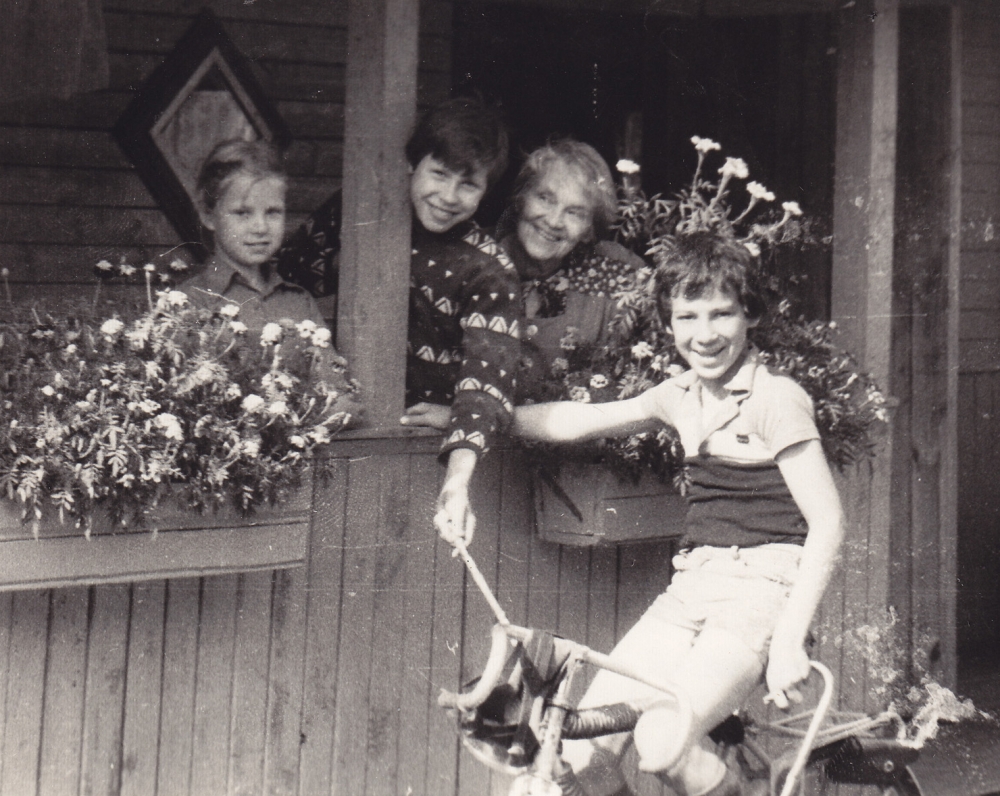 A. Liobytė su anūku Jonuku ir dailininko M. Vilučio vaikais savo sodyboje „Gyvatynėje“. Šniūrai, Molėtų r., 1983 m.