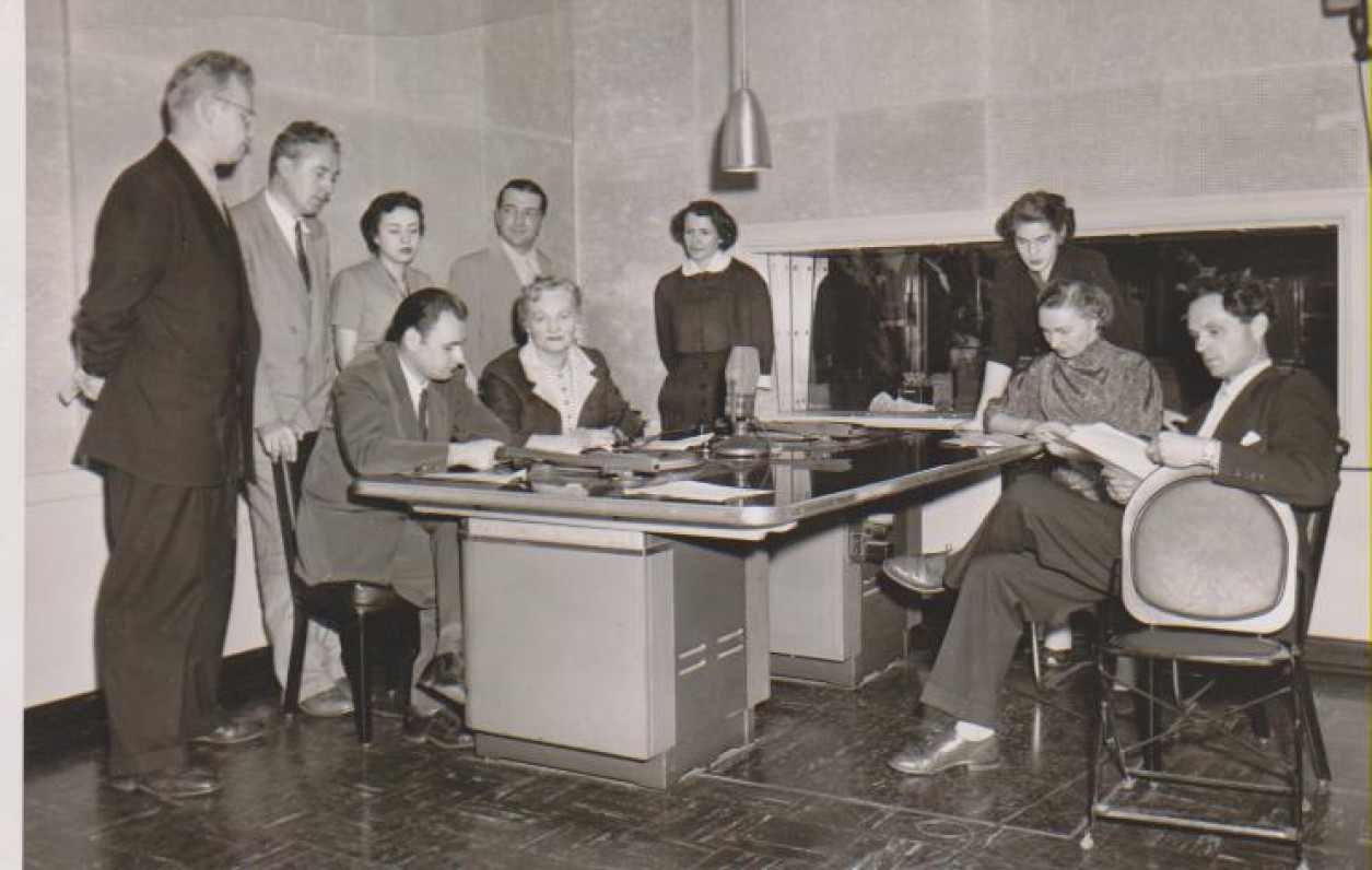 Dalia Sruogaitė (sėdi prie stalo) radijo stotyje su programos „Pelkių žiburėlis“ dalyviais. Čikaga, 1954 m.