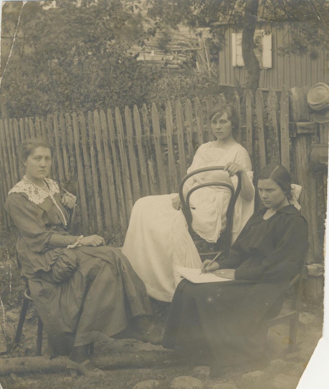 Bronė Buivydaitė (Tyrų Duktė) su draugėmis, 1928 m. Poetė sėdi susimąsčiusi, ant kelių popieriaus lapas, rankose plunksna