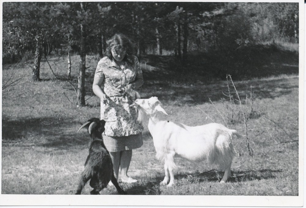 J. Degutytė šeria ožkas. Antroje fotografijos pusėje poetė užrašiusi „1967 m. ties Merkine“