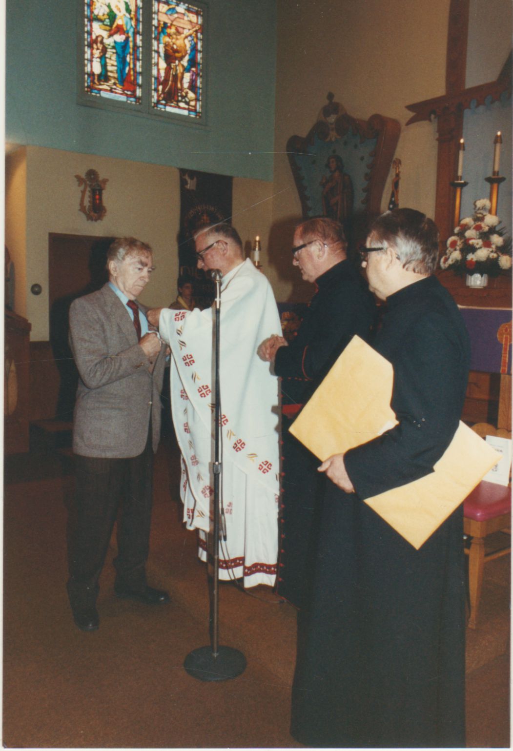 Popiežiaus Jono Pauliaus II apdovanojimo įteikimas šv. Kazimiero parapijos bažnyčioje Los Andžele 1988 m. kovo 6 d. Medalį B. Brazdžioniui sega prelatas Jonas Kučingis