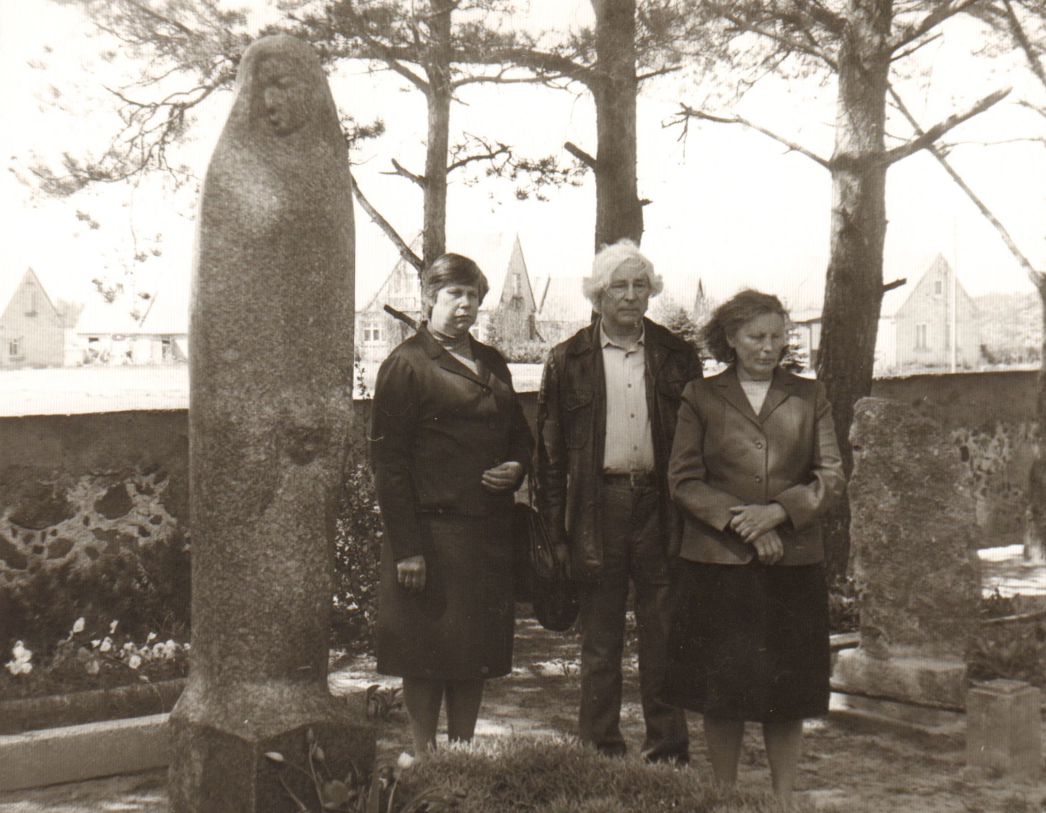 Pošūpių kapinėse prie paminklo tėvams. Rašytojui iš šonų stovi seserys Adolfa Avižiūtė (kairėje) ir Stasė Valančiunienė.  1991 m. rugsėjis. MLLM 76042
