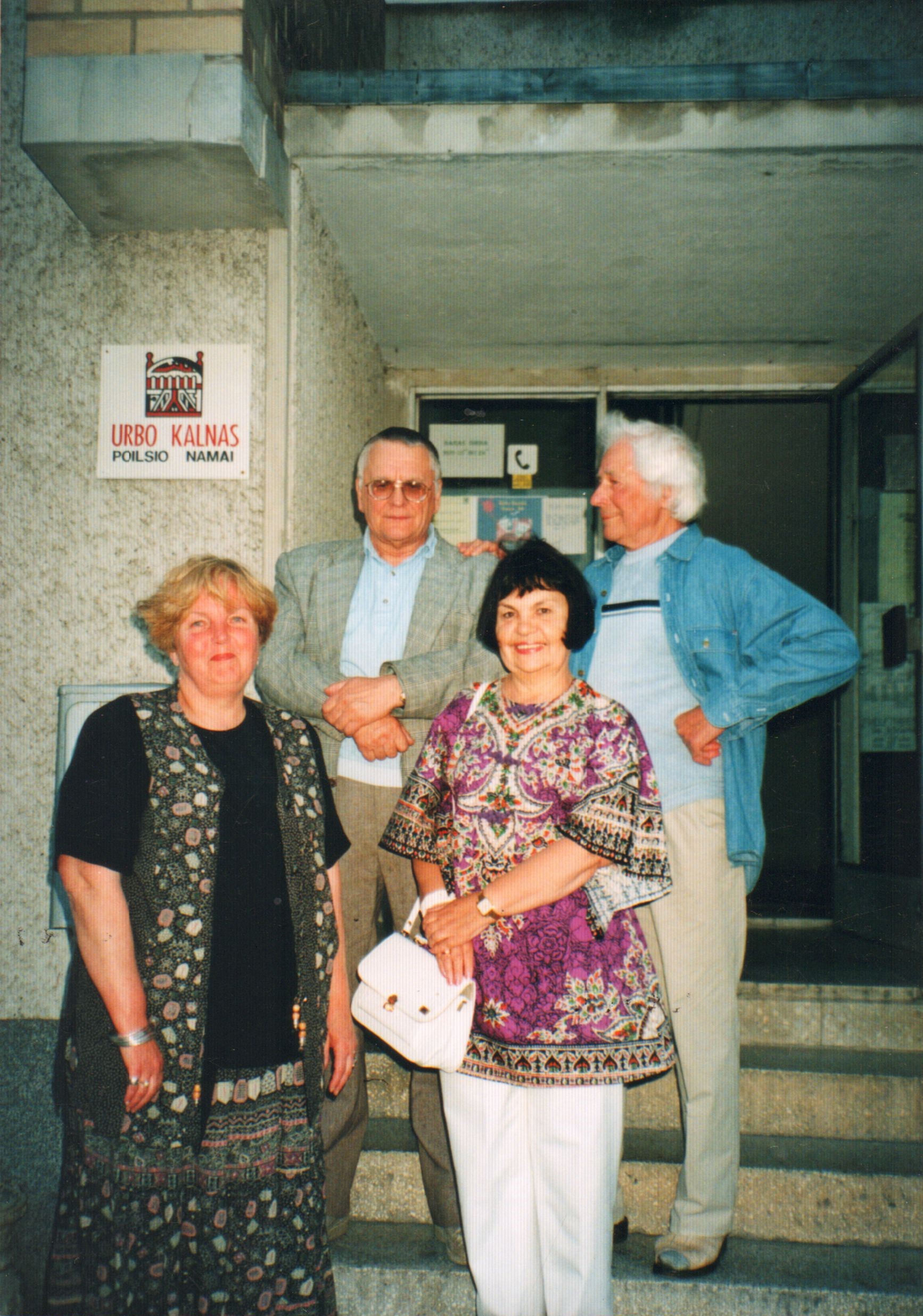 Ant rašytojų kūrybos namų „Urbo kalnas“ laiptų stovi: pirmoje eilėje iš kairės Sigita Baltakienė ir Irena Avyžienė, antroje eilėje: iš kairės Algimantas Baltakis ir Jonas Avyžius. Nida, 1997 m. rugpjūtis.  MLLM 76088