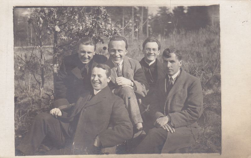 Linksma su draugais. Priekyje iš kairės sėdi J. Gutauskas ir P. V. Raulinaitis. Antroje eilėje sėdi     L. Gronis, E. Turauskas, V. Mykolaitis. Fribūras, 1921-03-20.  MLLM 121418