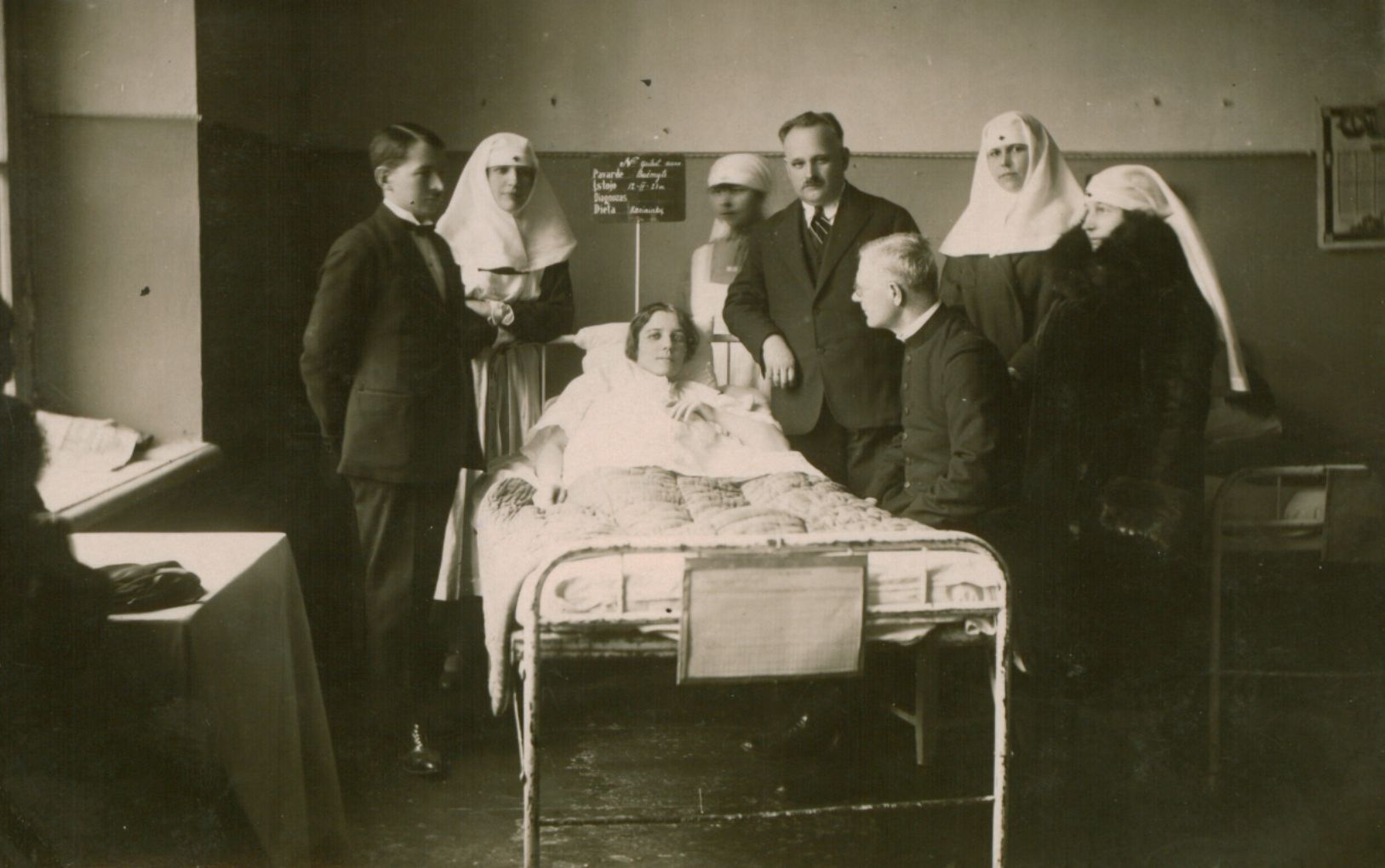 Kun. A. Sabaliauskas-Žalia Rūta (sėdi) prie ligonės Kauno karo ligoninėje. Fotografas nežinomas. 1928 m. MLLM 25217