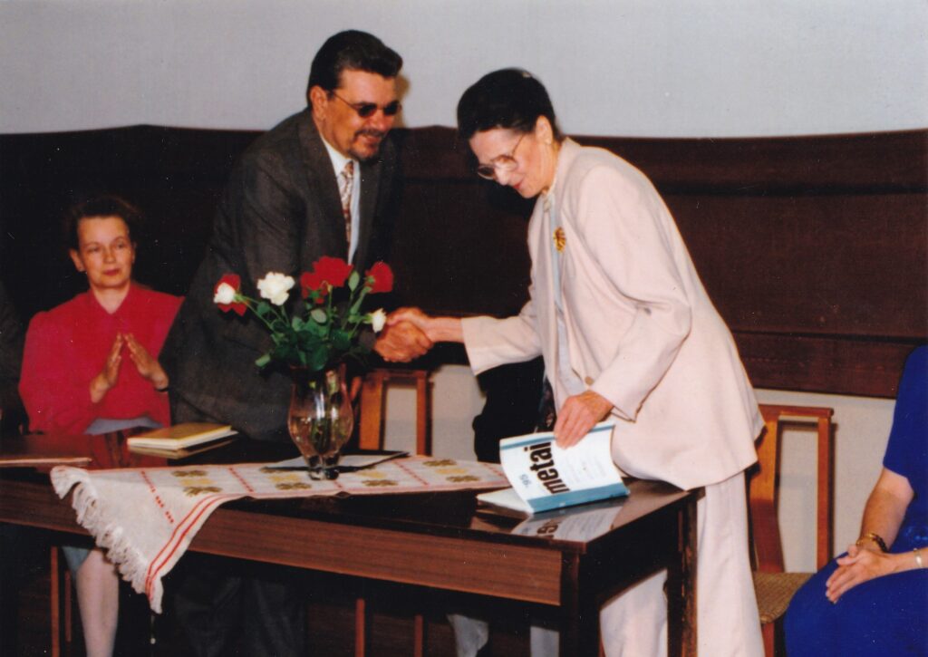 A. Vaičiulaičio premijos įteikimas R. Granauskui už apsakymą „Su peteliške ant lūpų“. Rašytoją sveikina J. Vaičiulaitienė, sėdi J. Sprindytė. Vilnius, 1995 m. GEK P50501