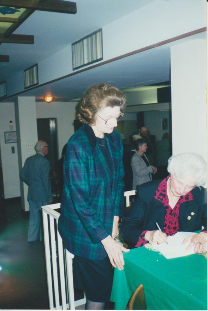 N. Jankutė rašo autografą dailininkei A. Sutkuvienei. 2000 m. MLLM 78619