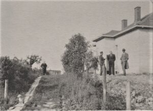 B. Sruoga, T. Reingardas, K. Penčyla ir nežinomas asmuo prie statomo namo