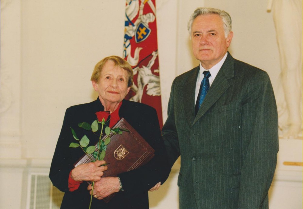 D. Sruogaitė su Lietuvos Respublikos Prezidentu Valdu Adamkumi po valstybinio apdovanojimo Žūstančiųjų gelbėjimo kryžiumi, skirto jos tėvams – B. Sruogai ir V. Daugirdaitei-Sruogienei (po mirties). Vilnius, 2002 m.