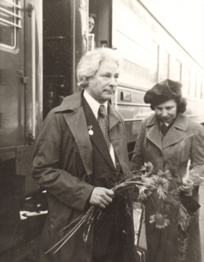 Rašytojas Jonas Avyžius Vilniaus geležinkelio stotyje, grįžęs iš Maskvos, po Lenino premijos įteikimo. Perone jį pasitinka žmona Irena. Vilnius, 1976 m. Sauliaus Markevičiaus nuotrauka. MLLM 23119