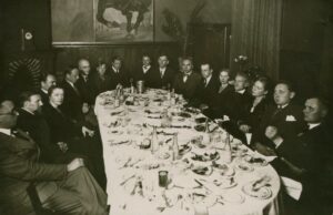 Iš dešinės sėdi: du neatpažinti asm., M. Rakauskaitė, J. A. Herbačiauskas, A. Galaunienė, J. Keliuotis, J. Banaitis, K. Jakubėnas, du neatpažinti asm., J. Aistis, P. Slavėnas, A. Miškinis, K. Pakštas, T. Herbačiauskienė, L. Gira. 1933 m. GEK 52574