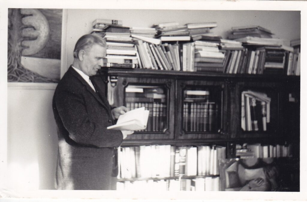 Rašytojas savo namuose, šalia asmeninės ilgus metus kauptos bibliotekos. Londonas. Apie 1960 m.