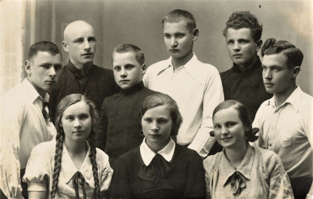 Biržų gimnazijos vyresnieji literatai su jaunųjų pirmininku – būsimuoju monsinjoru Kazimieru Vasiliausku (antroj eilėj antras iš kairės), Paulius Drevinis – pirmas iš kairės, antras iš kairės stovi Bronius Krivickas, iš dešinės pirmas Eugenijus Matuzevičius, antras – M. Indriliūnas. Apie 1937 m. Fotografė V. Bortkevičiūtė